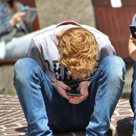 Symbolbild: Teenie schaut verstohlen aufs Handy